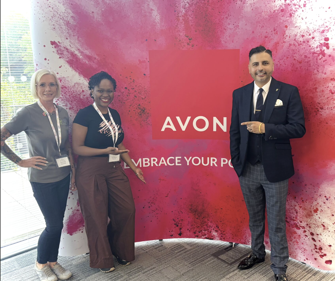 Joyce Mwape with Avon hosts in front of the Embrace Your Power backdrop